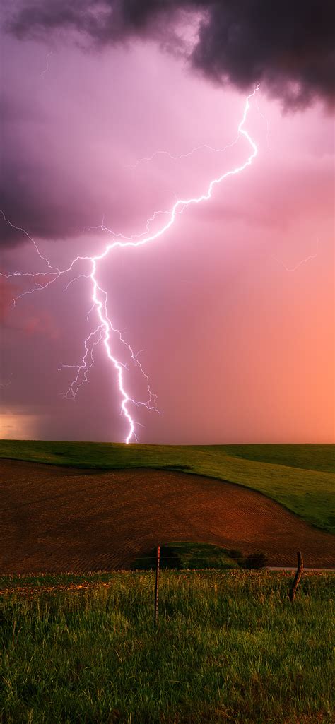 1242x2688 Thunderstorm Lightning Bolt Striking Down At Sunset In