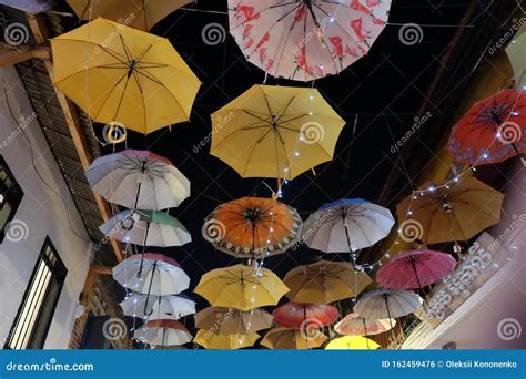 multi colored umbrellas are hung over the city street lots of hanging umbrellas editorial photo