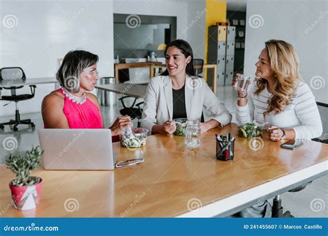 Transgender Latin Woman Eating Salad Bowl At Break Time With Women