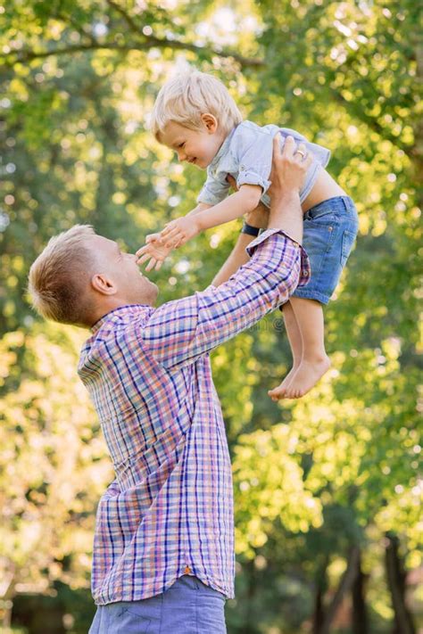 Young Dad Playing With His Son In The Park By Throwing Him Up Stock Image Image Of Fresh Park