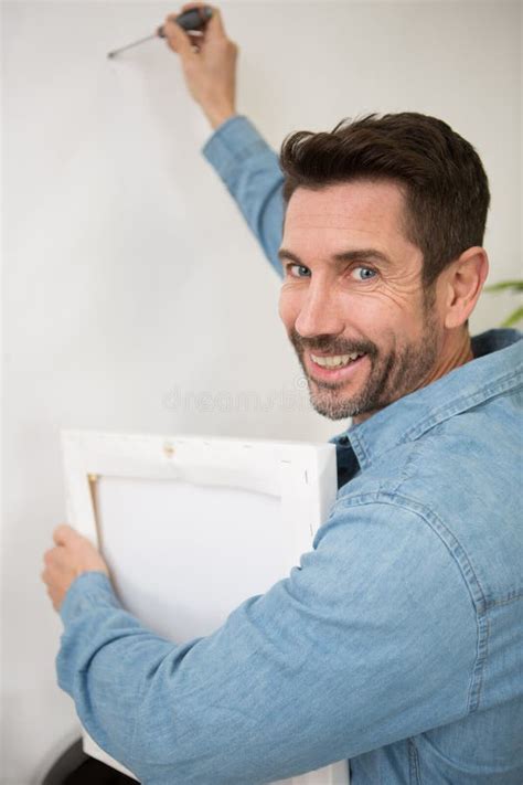 Man Hanging Up Painting On Wall Stock Image Image Of Home Mouth