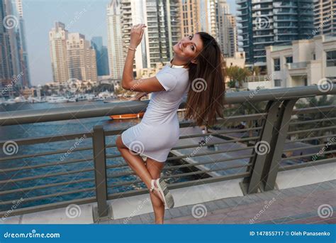 Happy Beautiful Tourist Woman In Fashionable Summer White Dress Walking