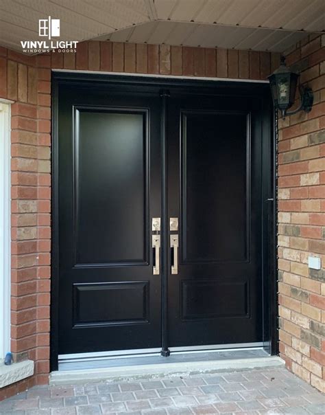 Two Black Double Doors With Gold Handles On Brick House Front Door And