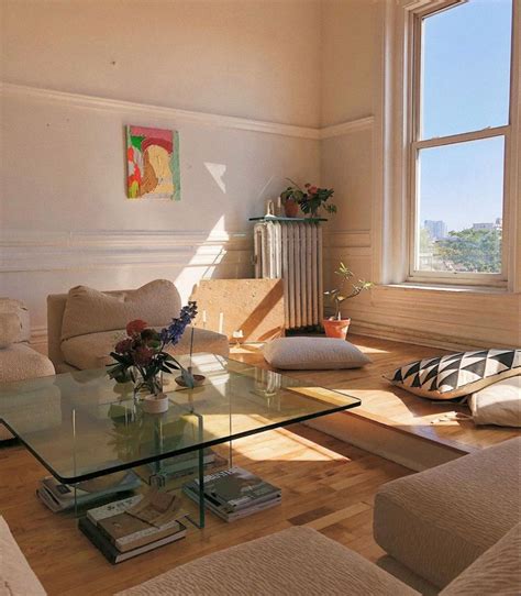A Living Room Filled With Furniture And A Large Window Covered In Sun