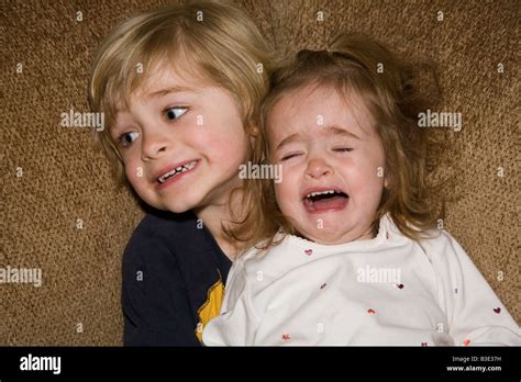 Big Brother Holding Crying Little Sister On His Lap Stock Photo Alamy