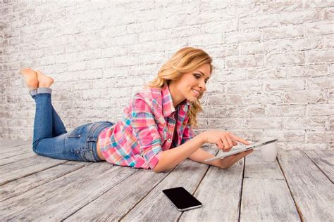 Pretty Young Woman Lying On Bean Bag Reading Book Stock Photo Image