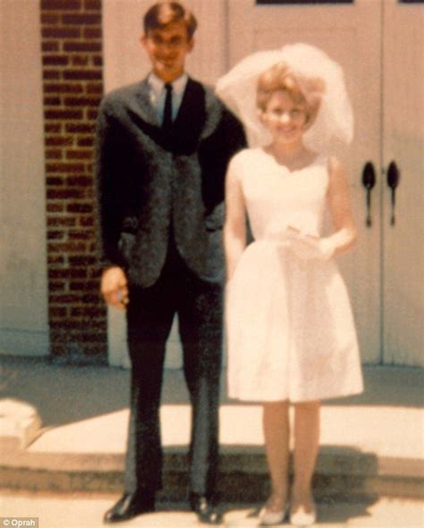 A Man In A Suit And Tie Standing Next To A Woman Wearing A Wedding Dress