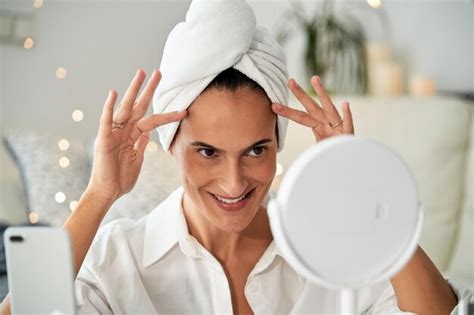 Premium Photo Cheerful Woman Doing Face Massage Looking At Mirror