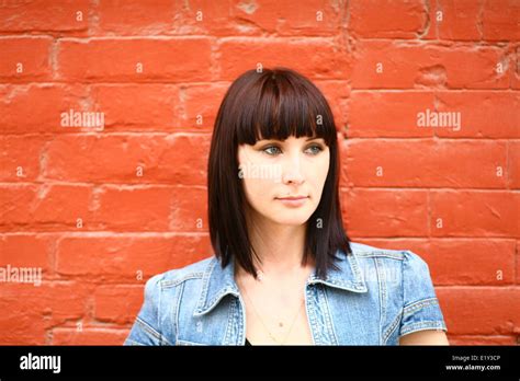 Brunette Girl Posing Against Red Brick Wall Stock Photo Alamy