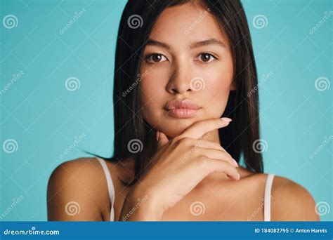 Portrait Of Beautiful Confident Asian Brunette Girl Thoughtfully Looking In Camera Over Colorful