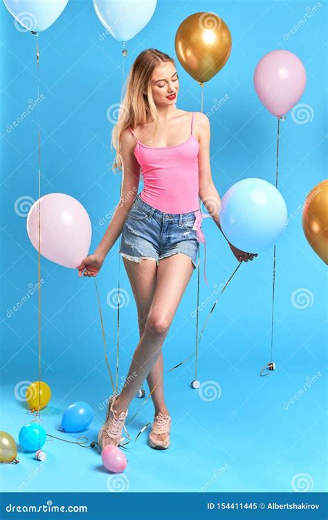 Romantic Awesome Blonde Girl Standing With Crossed Legs Among Balloons