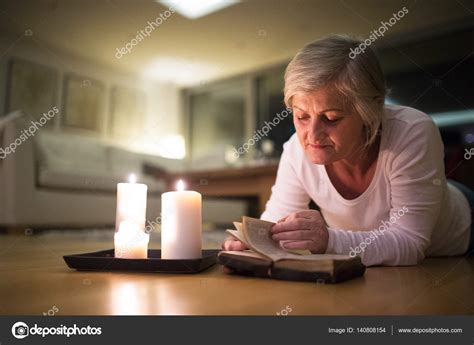 Senior Mujer Leyendo La Biblia Quema De Velas Al Lado De Ella — Foto