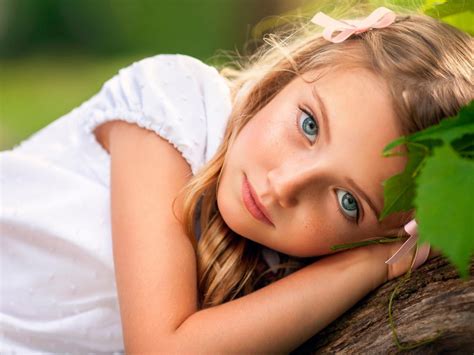 Ash Eyes Cute Little Girl Is Lying On Tree Trunk Wearing White Dress In