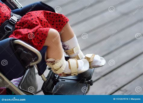 Disabled Girl Sitting In Wheelchair On Her Legs Orthosis Child