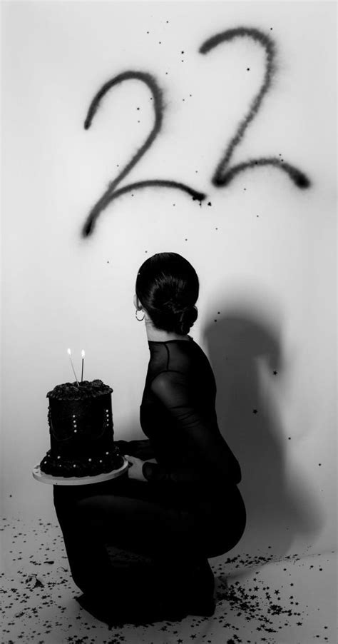 a woman kneeling down with a cake in front of her and the number twenty two written on it