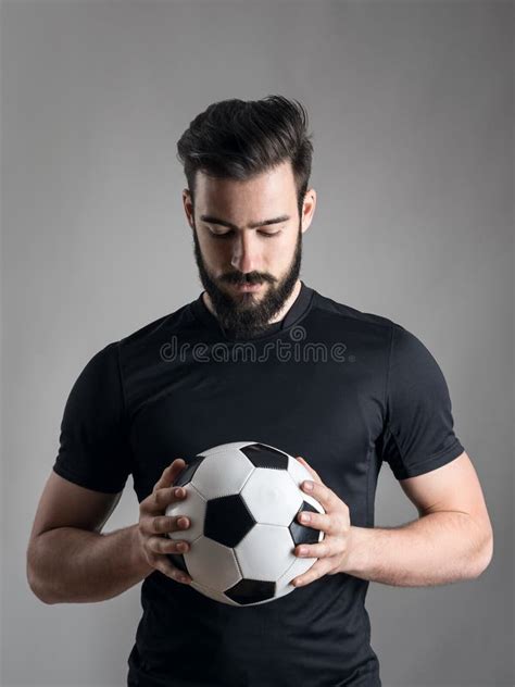 Intense Portrait Football Player Holding Looking Ball Focused Over Gray