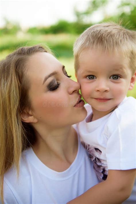 Jeune Maman Embrasse Son Fils Et Marche Dans Le Parc Photo Stock