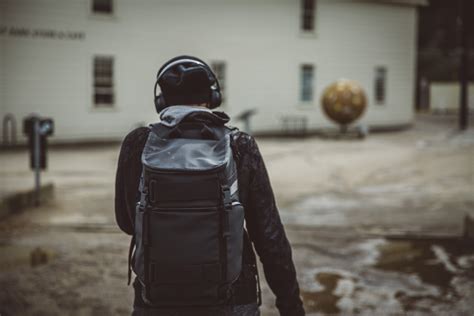 Guy Walking With Headphones And Backpack Rocket Republic