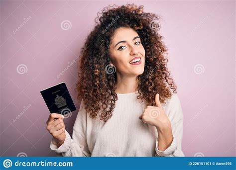 Beautiful Tourist Woman With Curly Hair And Piercing Holding Canada Canadian Passport Id With