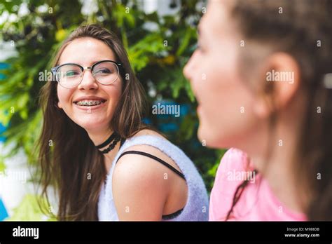 Happy Teenage Girl With Braces And Glasses Looking At Friend Stock