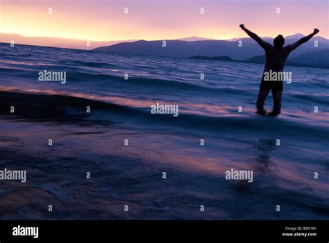 Sundown On Mountain Lake And Silhouette Men Stock Photo Alamy