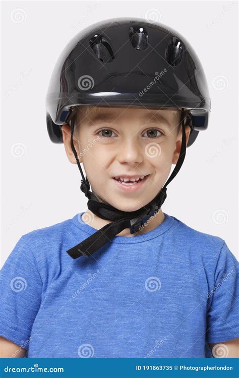 Portrait Of A Happy Little Boy Wearing Bicycle Helmet Over White