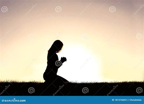 Young Christin Woman Praying Outside At Sunset On A Summer Day Stock