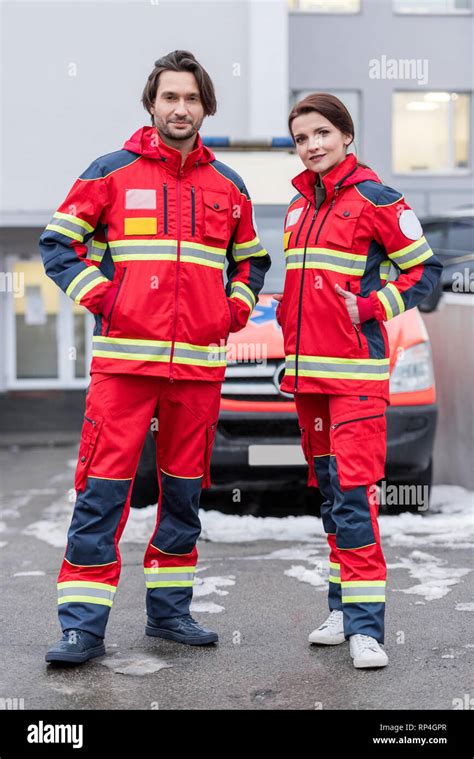 Full Length View Of Paramedics In Red Uniform Standing With Hands In
