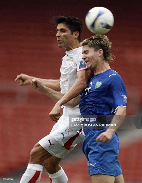 Iranian Player Vahid Hashemian Fights For The Ball With Uzbekistan