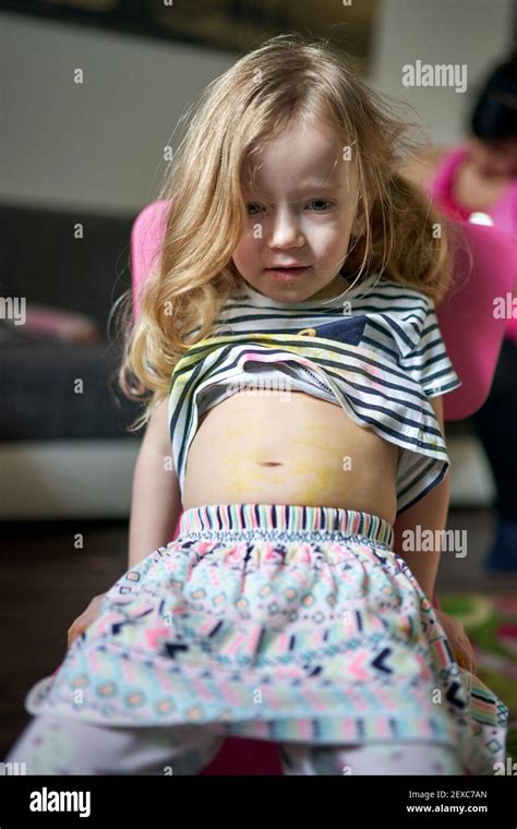 Cute Little Girl Artist Sitting On Chair Showing Her Pained Belly Stock