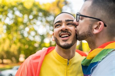 premium photo gay couple embracing and showing their love with rainbow flag