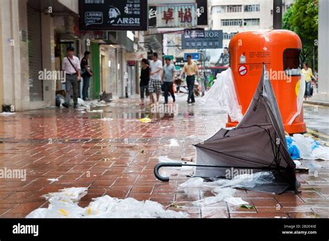 Broken Umbrella And Overflowing Rubbish Bin After A Tropical Storm In