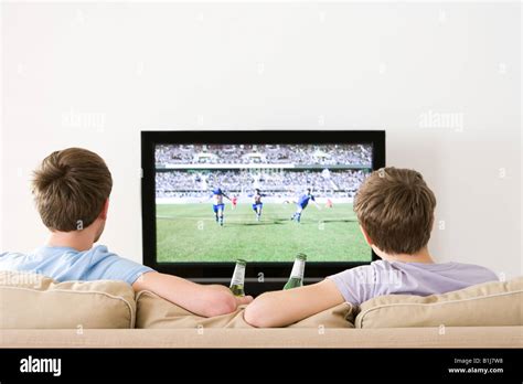 Two Young Men Watching Football On The Tv Stock Photo Royalty Free