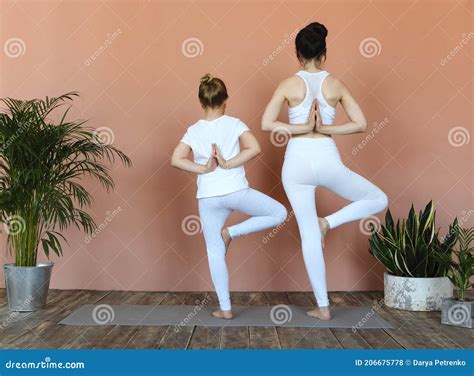 Smiling Mother And Daughter Practicing Yoga Together Stock Photo