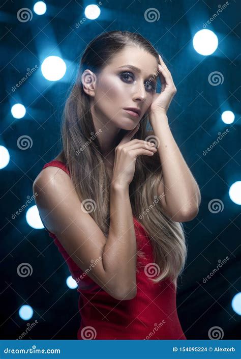 A Beautiful Long Haired Slim Girl Wearing A Red Bodysuit Sensually