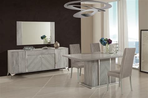 In this dining room from home.at.goldlay, a cool light gray acts as the canvas for bold oranges, yellows, and reds throughout the space. Nova Domus Alexa Italian Modern Grey Dining Table Set