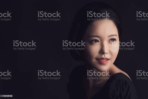 Beautiful Portrait Headshot Of Asian Korean Woman Posing Against Black