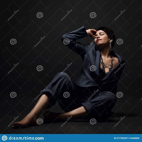 Short Haired Brunette Woman In Business Smart Casual Suit On Naked Body Sits On Floor With Eyes
