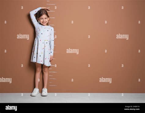Little Girl Measuring Her Height Near Color Wall Stock Photo Alamy
