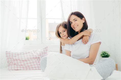 Cheerful Young Smiling Mother And Her Daughter Embrace Each Other Have