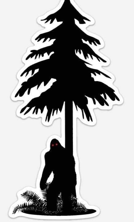 A Black And White Image Of A Bigfoot Under A Pine Tree With Red Eyes