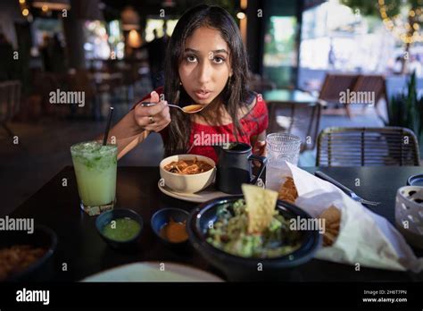 Young Asian Woman Eating Tortilla Soup At A Mexican Restaurant Stock