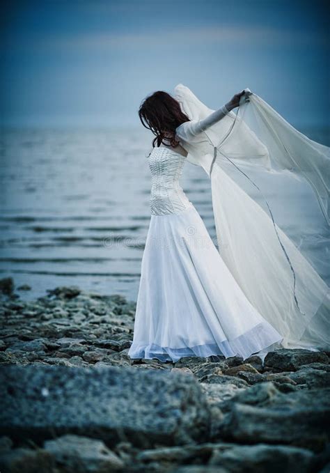 Beautiful Sad Girl In White Dress Standing On Sea Shore Stock Image