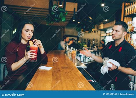 A Girl That Is Not Satisfied With The Cocktail That Barman Has Made For Her She Looks