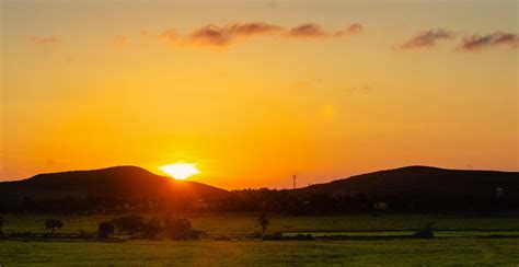 Sunset Between The Hills And The Lit Up Valley Beneath Free Image By