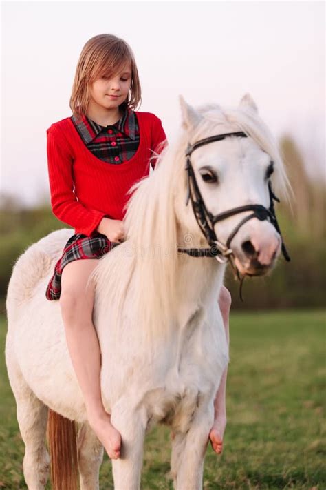 The Baby Girl Is Sitting On A Pony Thoughtful Stock Photo Image Of
