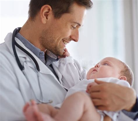 Happy Male Doctor Pediatrician And Holding Baby For Hospital