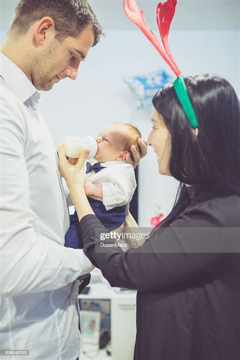 Proud Mother And Father Smiling At Their Newborn Baby High Res Stock