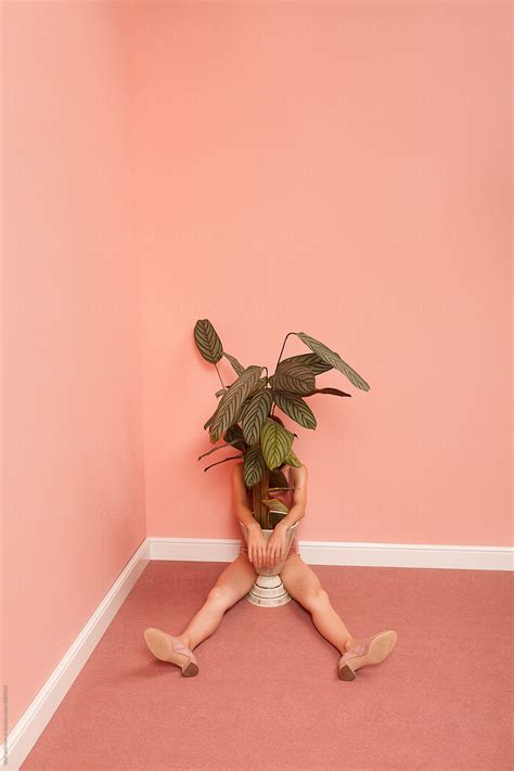 Woman In A Pink Room Hiding Behind A Plant By Stocksy Contributor Ulas Merve Stocksy
