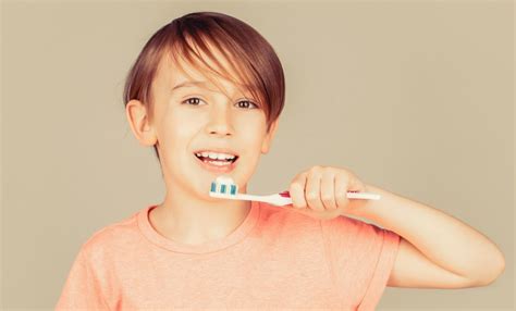 Premium Photo Joyful Child Shows Toothbrushes Little Boy Cleaning